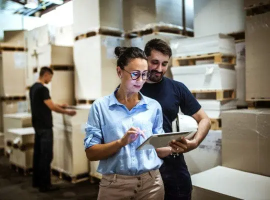 Warehouse supervisor walking and talking with senior manager